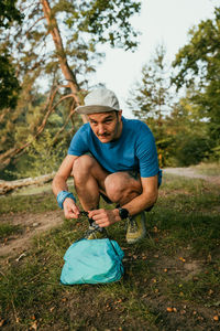 Full length portrait of man crouching on field