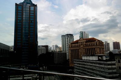 Buildings in city against cloudy sky