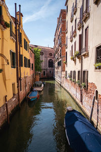 Boats in canal amidst buildings in city