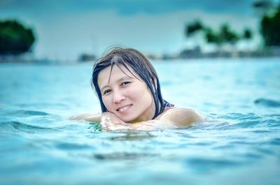 Portrait of smiling young woman swimming in pool