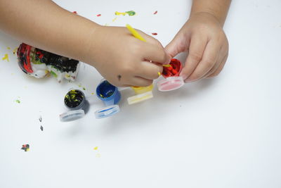 High angle view of baby hand holding toy on table