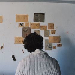 Rear view of woman standing against wall