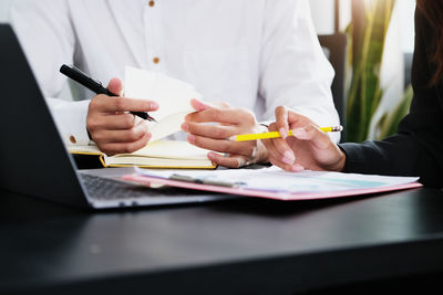 Cropped image of people working on table