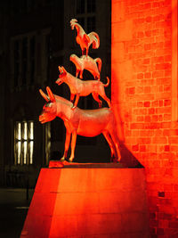 Statue against orange wall