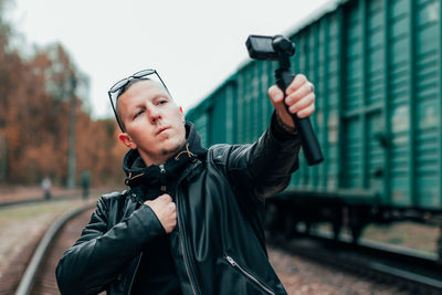 Portrait of man photographing through train