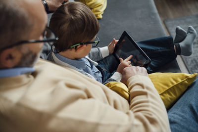 Boy e-learning through tablet pc by grandfather at home