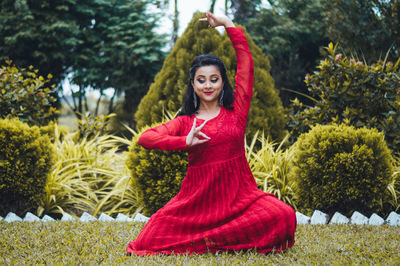 Portrait of woman with red flowers in park