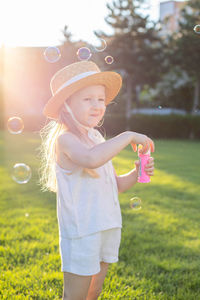 Portrait of cute girl blowing bubbles at park