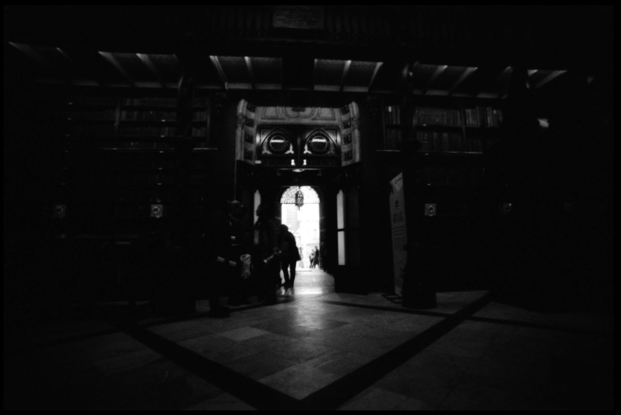 REAR VIEW OF MAN WALKING IN BUILDING