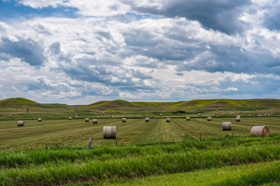 Hay bales on field against sky