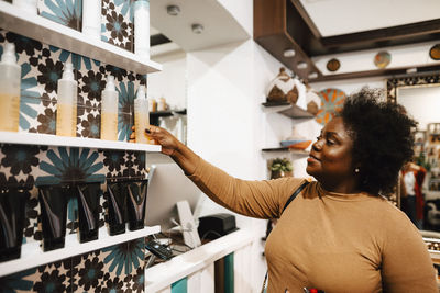 Mature female customer buying beauty product at hair salon