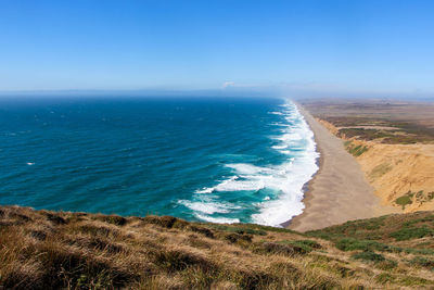 Scenic view of sea against clear blue sky