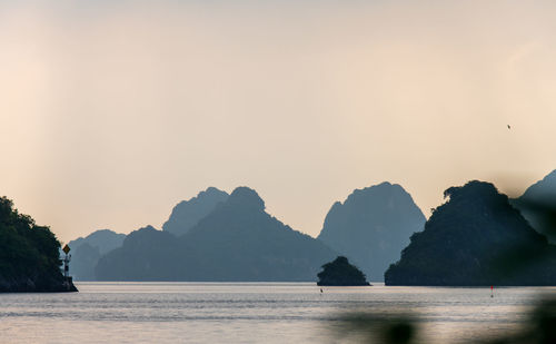 Scenic view of sea and mountains against clear sky