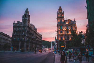 View of city street and buildings at sunset