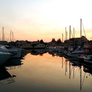 Sailboats moored at harbor