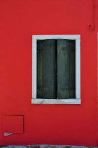 Close-up of window on red wall