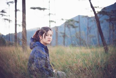 Side view portrait of young woman on field