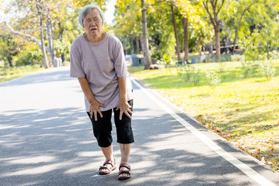 Full length portrait of man standing on road
