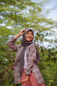Portrait of young woman standing in forest