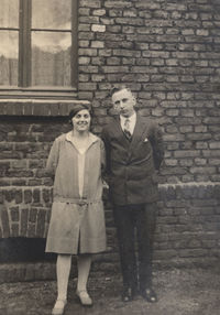 Portrait of a woman standing against brick wall