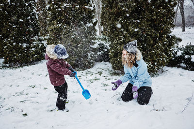 Happy family, mother and son having fun outdoors in winter snowy nature background. mom and kid