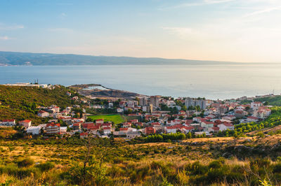 High angle view of townscape by sea against sky