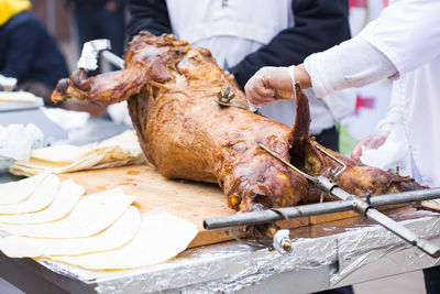 Man holding meat on barbecue grill