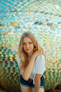 Portrait of young woman standing against decorations