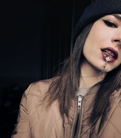 Close-up portrait of young woman in hat wearing jewelry