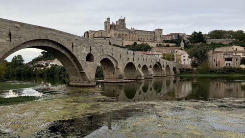 Arch bridge over river against sky