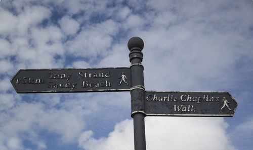 Low angle view of sign against sky