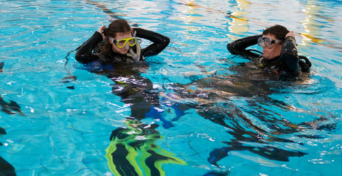 High angle view of friends with swimming goggles in pool