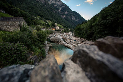 Stream by rocks against mountains