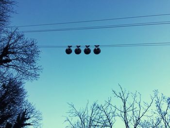 Low angle view of bare trees against blue sky