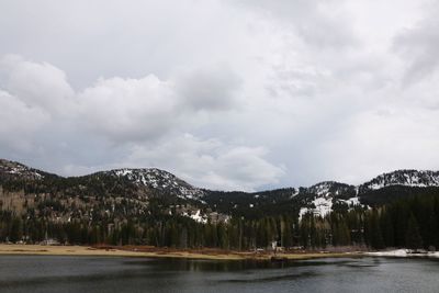 Scenic view of lake by mountains against sky