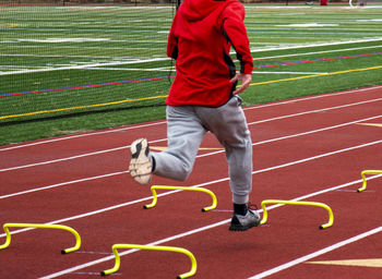 Low section of man playing soccer on field