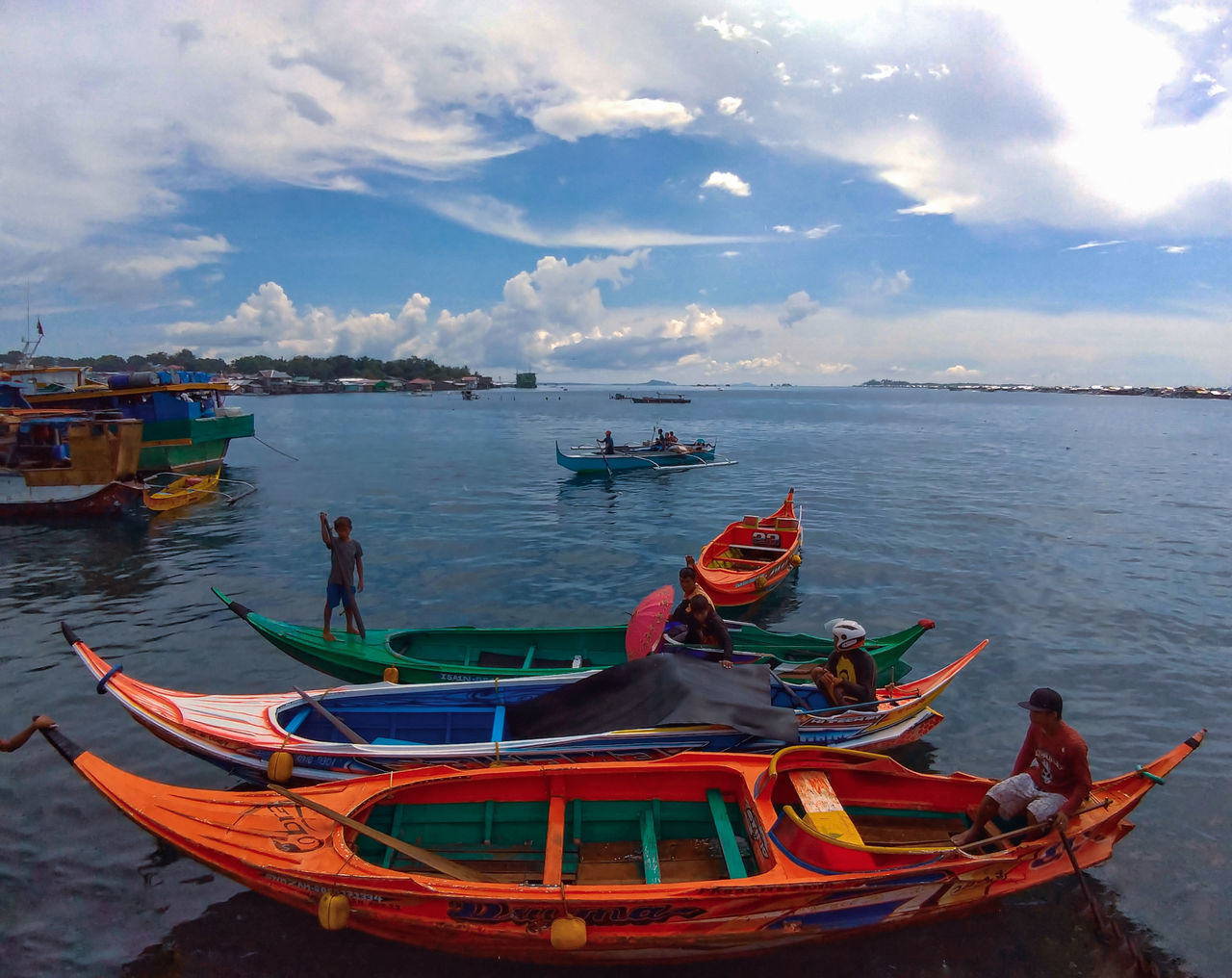 FISHING BOATS MOORED ON SEA AGAINST SKY