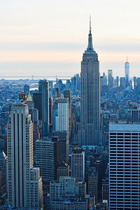 Modern buildings in city against sky during sunset