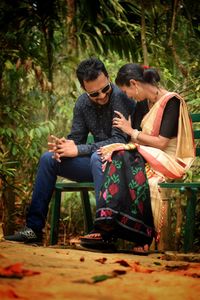 Young couple sitting on tree