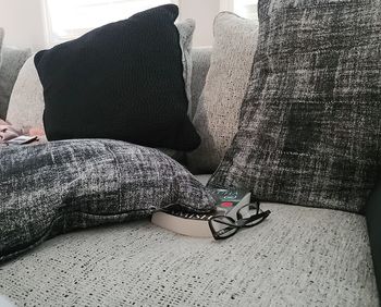 Low section of woman sitting on sofa at home