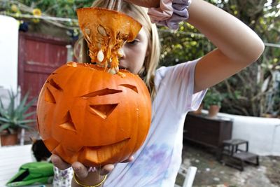 Midsection of woman with pumpkins