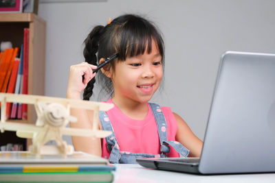 Close-up of boy using laptop at home