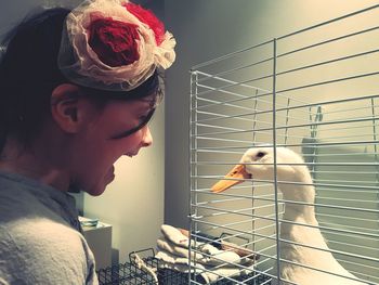 Portrait of teenage girl holding bird in cage