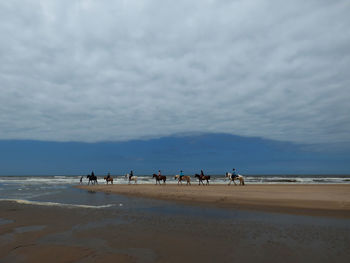People on beach against sky