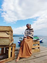 Portrait of woman standing against sea