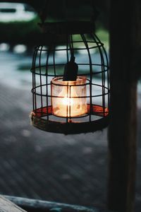Close-up of illuminated light bulb hanging on street