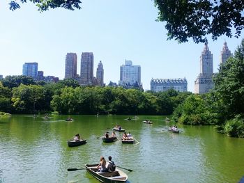 Boats in river with city in background