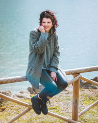 Portrait of smiling young woman sitting outdoors