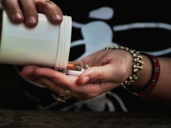 Close-up of person removing medicines from bottle