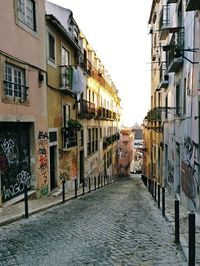 Alley amidst buildings in city against sky